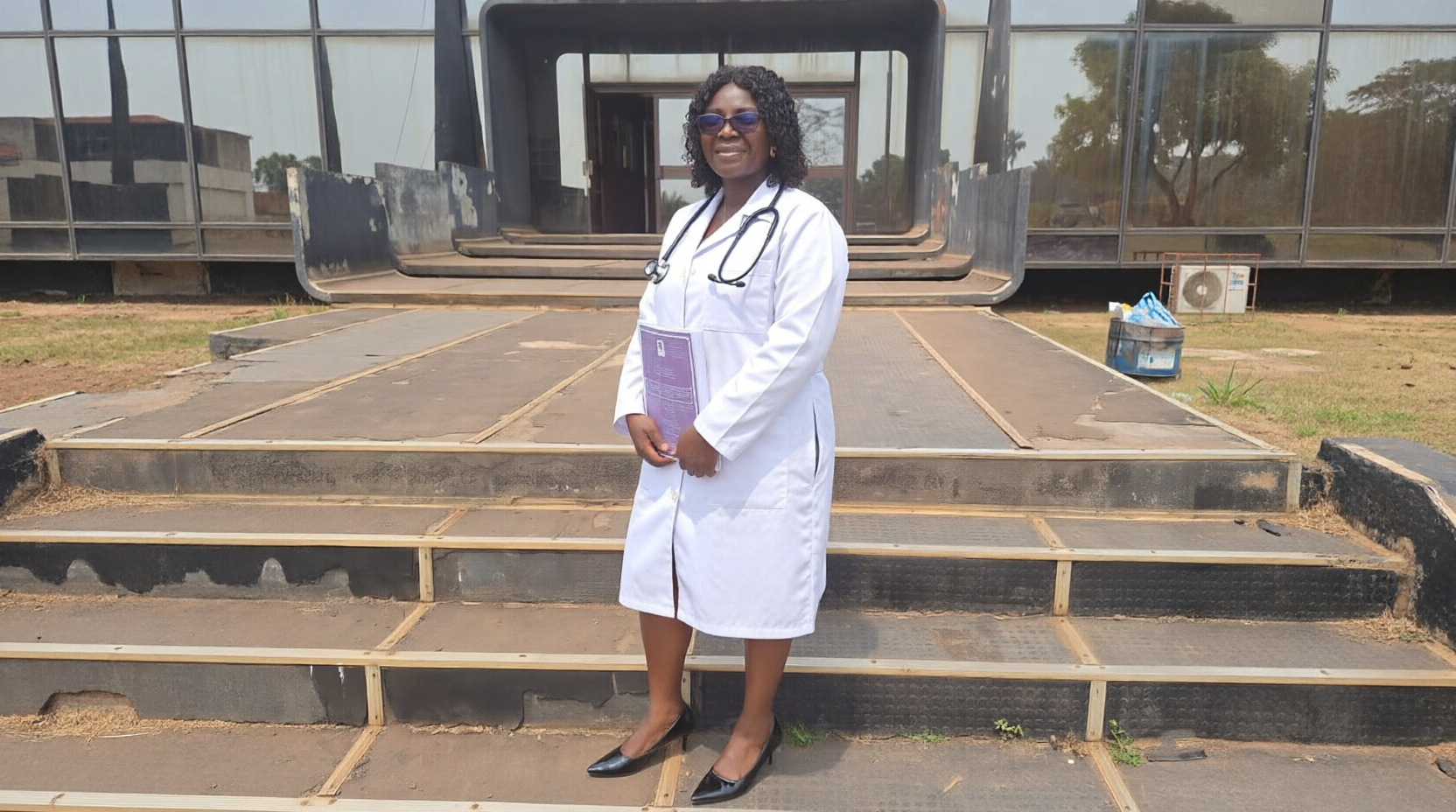 Clinical lead in a white coat outside a building