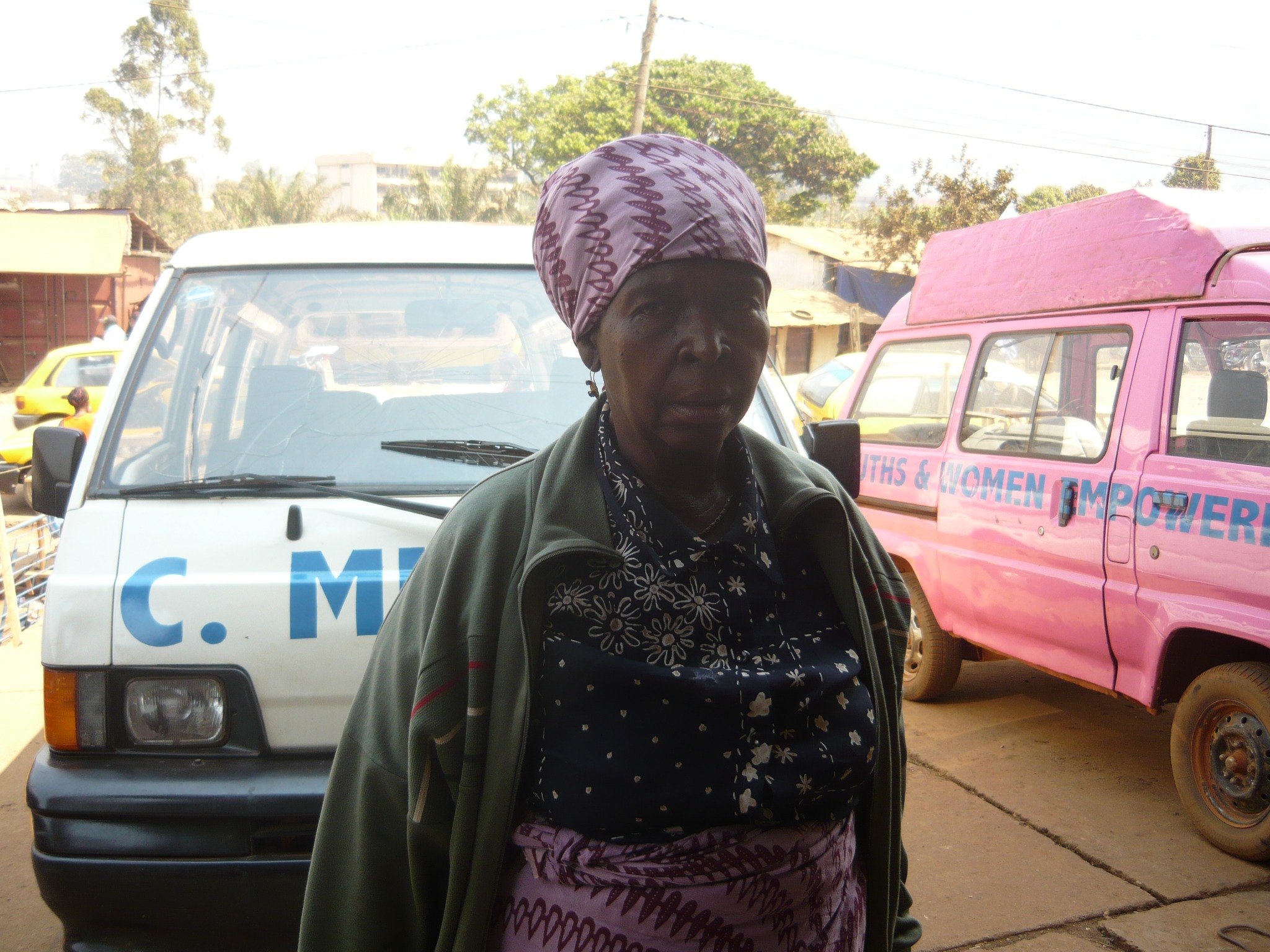 Woman beside a white van with a pink outreach van behind her